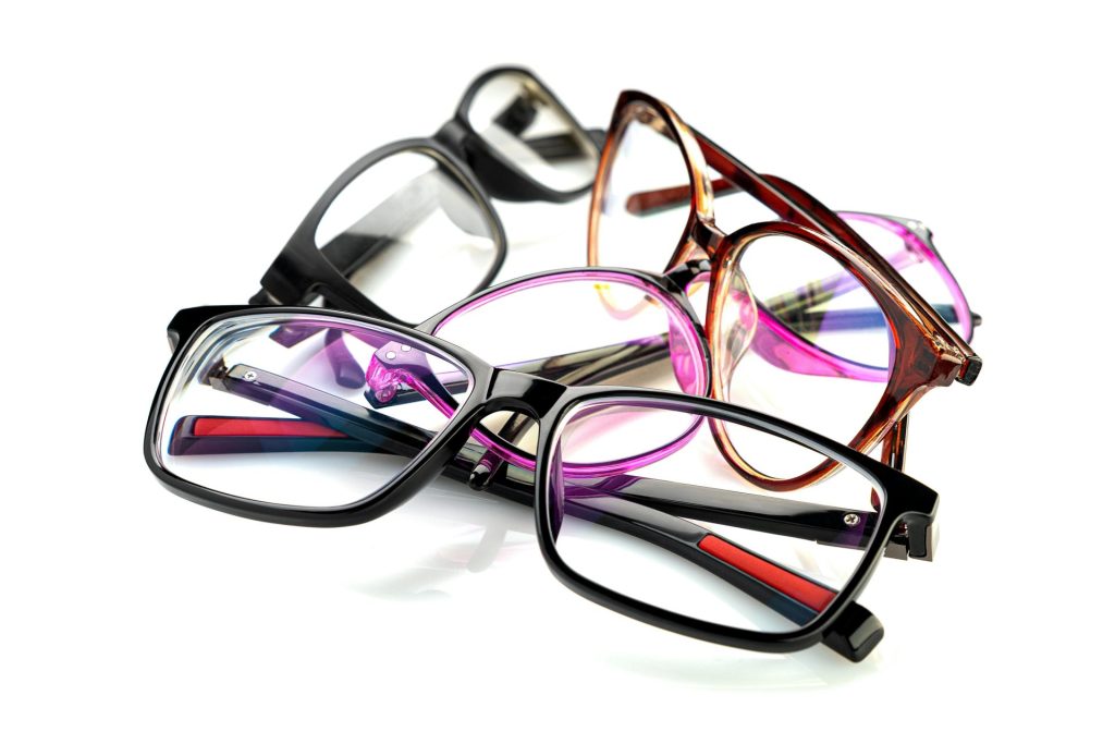 Une collection colorée de lunettes disposées sur un fond blanc.