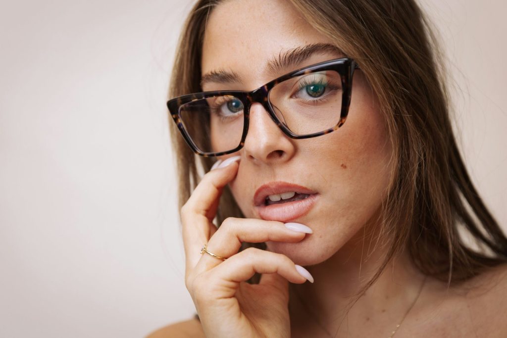 A young woman wearing stylish tortoiseshell glasses